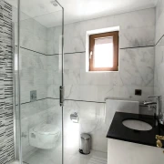 Jasna łazienka wyłożona białym marmurem Mugla
